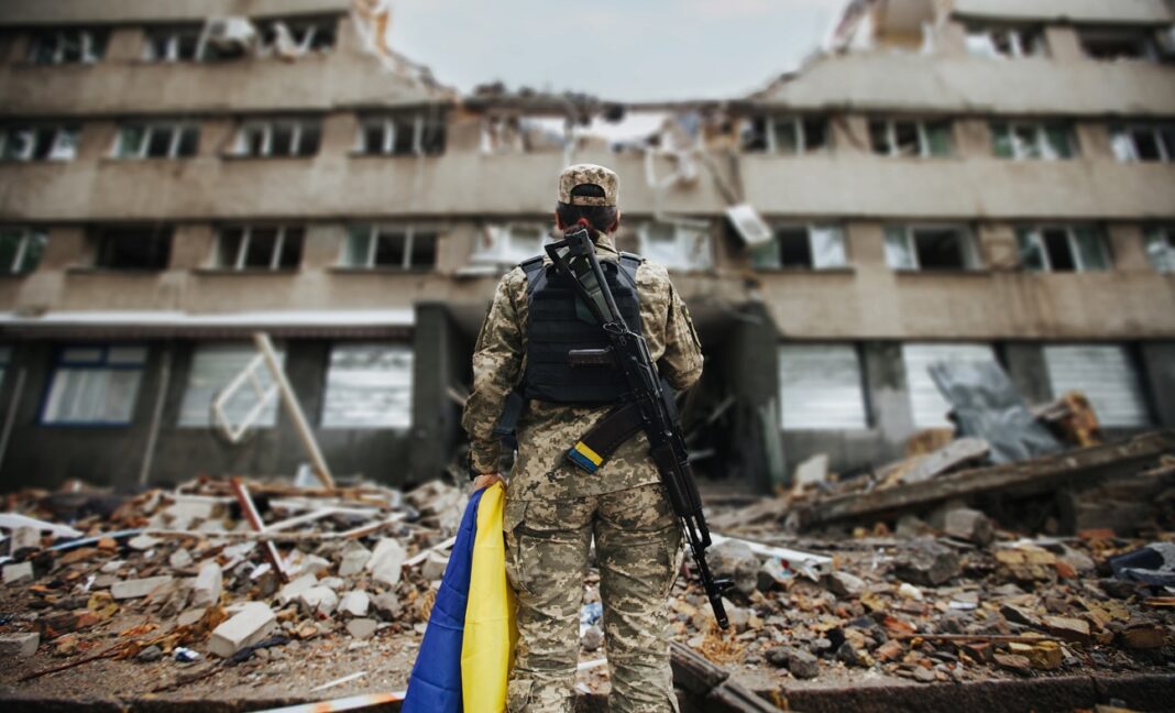 Українська військова біля напівзруйнованої російським обстрілом будівлі. Фото: Bakerinstitute